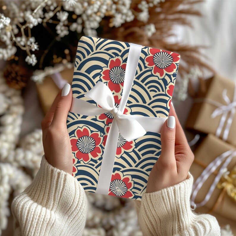 Puede incluir: Un regalo envuelto en papel estampado con flores rojas y olas azul marino sobre fondo crema. Est&aacute; atado con una cinta y un lazo de sat&eacute;n blanco. El tema es el de los regalos.