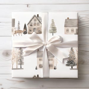 May include: White gift wrap with a repeating pattern of watercolour houses, trees, and a deer. The wrap is tied with a white satin ribbon and bow. The houses have grey roofs and are surrounded by winter trees.
