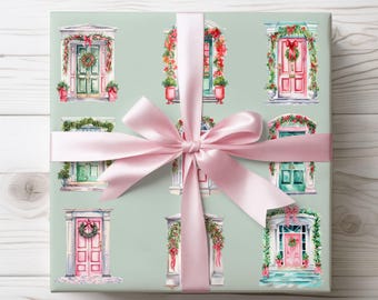 Könnte beinhalten: Geschenkpapier mit Aquarellillustrationen von dekorierten Türen in Grün-, Rosa- und Weißtönen. Ein hellrosa Satinband ist zu einer Schleife um das verpackte Geschenk gebunden. Der Hintergrund ist hellgrün.