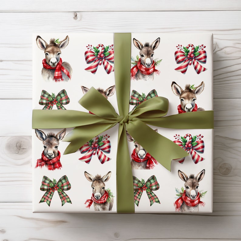 May include: A wrapped gift with white wrapping paper featuring a pattern of watercolor donkeys wearing red plaid scarves. The paper also has images of Christmas bows and candy canes. An olive green satin ribbon is tied around the gift.
