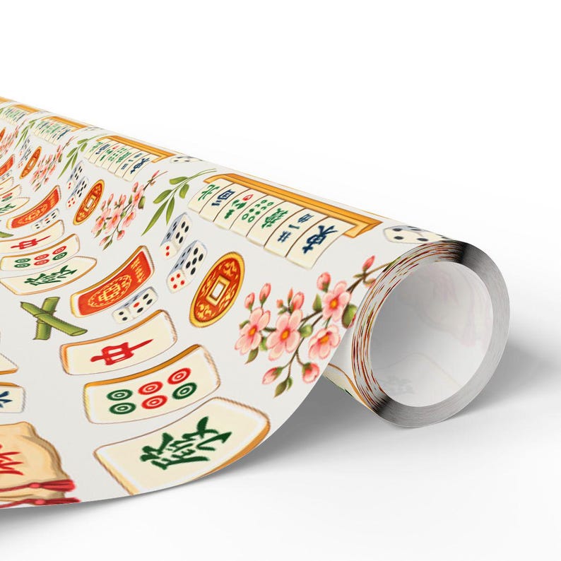 May include: Rolled wrapping paper featuring a repeating pattern of Mahjong tiles, dice, and cherry blossoms in shades of red, green, gold, and white. The paper is rolled up, revealing the patterned design.