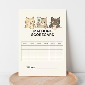 May include: A cream-colored Mahjong Scorecard featuring three cartoon cats holding Mahjong tiles. The scorecard has spaces for players, game scores, and a winner section. The text "MAHJONG SCORECARD" is printed in black.