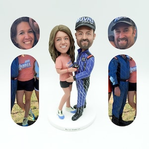 May include: A custom-made figurine of a couple, the woman is wearing a pink shirt and the man is wearing a blue racing suit with a black and white chequered pattern. The man is holding a trophy that says "World Champion".