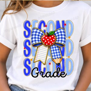 Könnte beinhalten: Ein weißes T-Shirt mit einem Grafikdesign, das den Text "SECOND GRADE" in Blau und Schwarz zeigt. Das Motiv enthält eine blau-weiß karierte Schleife, einen roten Apfel mit weißen Punkten, ein liniertes Blatt Papier und einen Bleistift.