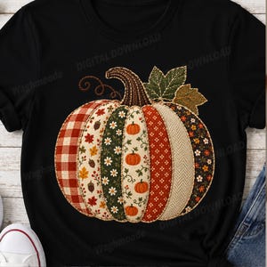 Könnte beinhalten: Ein schwarzes T-Shirt mit einer großen, zentralen Grafik eines Kürbisses, der aus vertikalen Patchwork-Segmenten besteht. Die Segmente zeigen verschiedene herbstliche Muster, darunter rotes Karomuster, Blumenprints, Eicheln und Blätter.