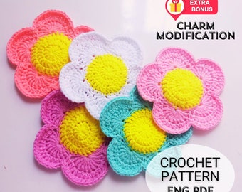May include: Five crocheted flower motifs in pink, white, turquoise, and yellow. The flowers are layered on top of each other. The text "CHARM MODIFICATION" and "CROCHET PATTERN ENG PDF" is visible in the image.