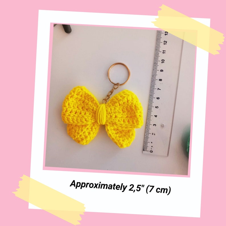 May include: A yellow crocheted bow keychain with a gold metal ring. The bow is approximately 2.5 inches (7 cm) wide.