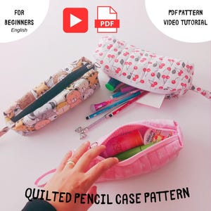 Peut inclure: Trois trousses à crayons matelassées ouvertes sont présentées. L'une présente un motif d'animaux de dessin animé, une autre un motif de cerises et la troisième est rose. Le texte "QUILTED PENCIL CASE PATTERN" est visible en bas.