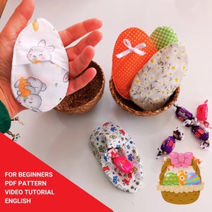 May include: Easter-themed fabric eggs in a woven basket, featuring various patterns like polka dots, floral, and bunny prints. The image also includes wrapped candies and a small basket with decorated eggs. Text on the image reads: FOR BEGINNERS PDF PATTERN VIDEO TUTORIAL ENGLISH.