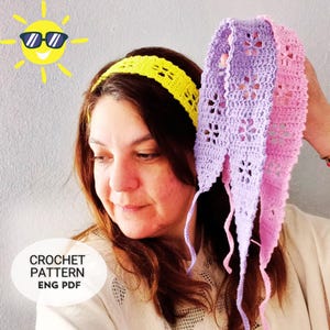 May include: A woman holds a crochet headband in shades of purple and pink, with a yellow headband on her head. The crochet headbands have a floral pattern. The image includes a cartoon sun with sunglasses and the text "CROCHET PATTERN ENG PDF".