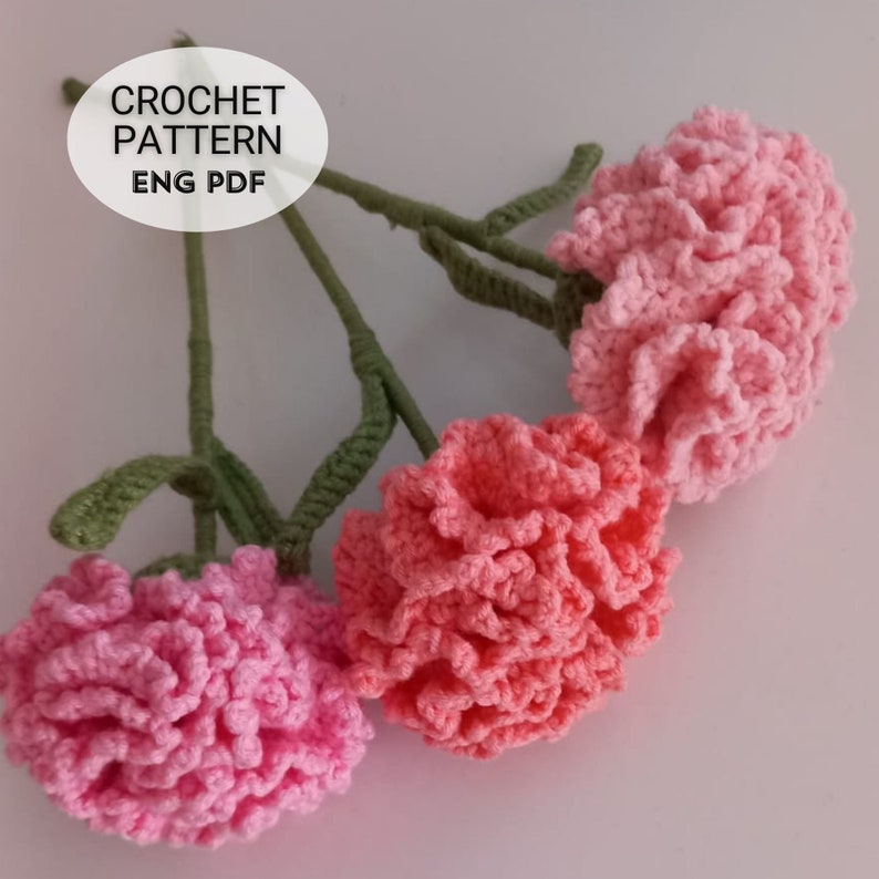 May include: Three crocheted pink carnations with green stems. Crochet pattern ENG PDF.