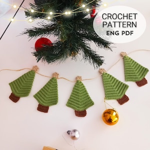 May include: A garland of crocheted green Christmas trees with brown trunks, strung with twine, on a white background. The text "CROCHET PATTERN ENG PDF" is visible in the top right corner of the image.