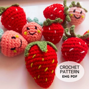 May include: A selection of handmade crochet strawberries in shades of red and pink, some with smiling faces. The strawberries have green leafy tops and white seed details. The image includes text that says "CROCHET PATTERN ENG PDF".