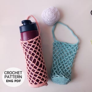 May include: Two crocheted water bottle holders, one pink and one light blue, with a white crocheted ball. The pink holder contains a maroon water bottle. The text "CROCHET PATTERN ENG PDF" is visible.
