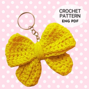 Può includere: Un portachiavi a forma di fiocco lavorato a uncinetto giallo con un anello in metallo dorato. CROCHET PATTERN ENG PDF.