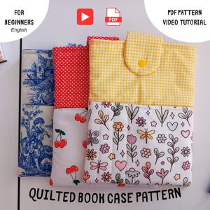 Puede incluir: Tres fundas para libros acolchadas rectangulares con distintos diseños de tela: una con estampado toile de Jouy azul y blanco, otra con parte superior de lunares rojos y blancos y parte inferior de cerezas, y otra con cuadros amarillos y flores.
