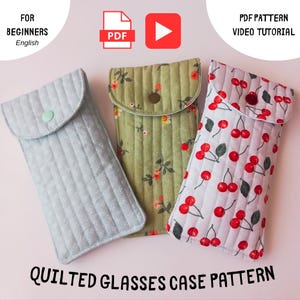 May include: Three quilted glasses cases in pale blue, green floral, and cherry print fabrics. Each case has a flap closure with a button. Text reads "Quilted Glasses Case Pattern", "For Beginners", and "PDF Pattern Video Tutorial".