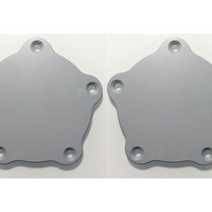 Könnte beinhalten: Zwei graue Metall-Ventildeckel mit jeweils fünf Löchern.