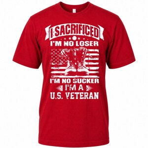 May include: Red t-shirt with a white graphic featuring combat boots in front of an American flag design. The text reads "I SACRIFICED I'M NO LOSER I'M NO SUCKER I'M A U.S. VETERAN."