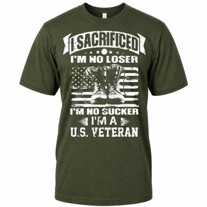 May include: Olive green t-shirt with white text and a graphic of combat boots in front of an American flag. The text reads "I SACRIFICED I'M NO LOSER I'M NO SUCKER I'M A U.S. VETERAN."