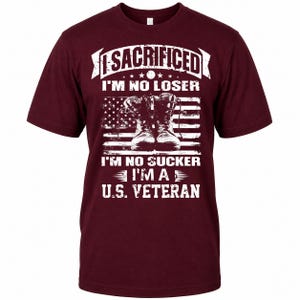 May include: A maroon t-shirt with a graphic design. The design features the text "I SACRIFICED I'M NO LOSER" above an American flag with combat boots and the text "I'M NO SUCKER I'M A U.S. VETERAN".
