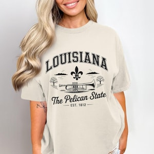 ルイジアナ州ペリカンTシャツ、フルール・ド・リス・トランペットTシャツ、ニューオーリンズ・ミュージックTシャツ、1812年創業の記念品、ヴィンテージ・ルイジアナTシャツ