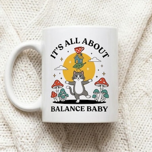 Mug Balancing Cat on Unicycle with Text It's All About Balance Baby