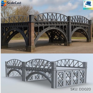 Puede incluir: Se muestran dos modelos de puentes, uno en gris oscuro y otro en gris claro. El puente gris oscuro tiene pilares de ladrillo y un diseño de arco detallado. El puente gris claro tiene un diseño más simple con un patrón de X. Los puentes están sobre un fondo natural al aire libre.