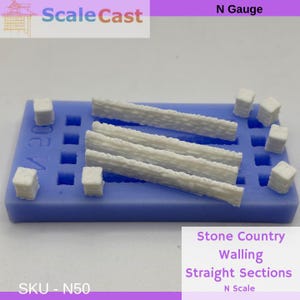 May include: A blue mould containing white model railway stone walling and square posts. The text "Scale Cast" and "Stone Country Walling Straight Sections" are visible. The scale is N Scale.