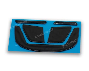 May include: A set of five black rubber mouse pads designed to improve grip and comfort while gaming. The pads are shaped to fit the contours of a mouse and are designed to be used on a variety of surfaces.