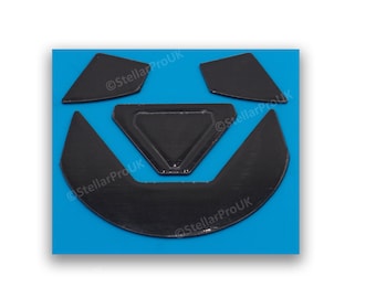 May include: A set of four black mouse feet pads for a computer mouse. The pads are shaped like a triangle, a crescent moon, and two smaller triangles.