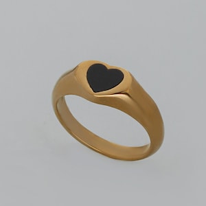 May include: A gold ring with a black heart-shaped inlay.