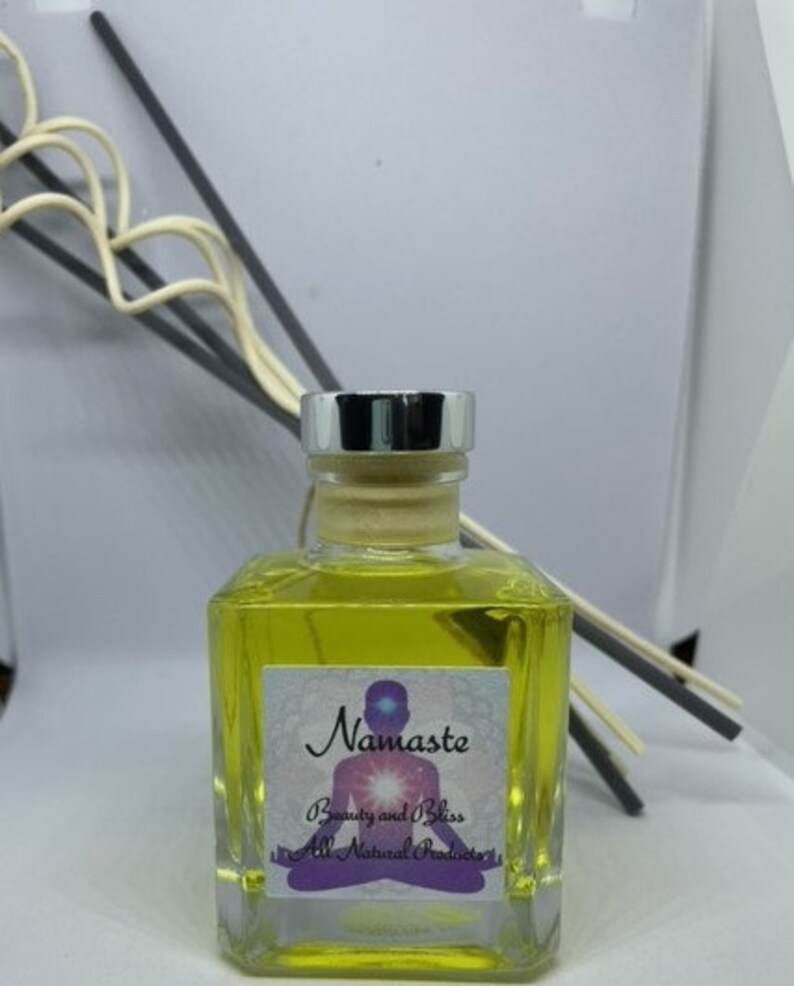 Peut inclure: Une bouteille en verre transparente contenant un liquide jaune. La bouteille a un couvercle argent&eacute; et une &eacute;tiquette qui indique "Namaste Beauty and Bliss All Natural Products".