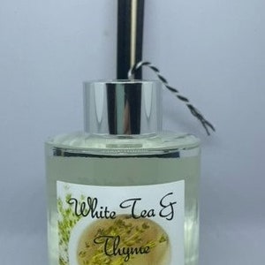 Peut inclure: Une bouteille en verre transparente avec un couvercle argent&eacute; et des roseaux noirs et blancs. La bouteille contient une huile de diffuseur avec une &eacute;tiquette qui indique "White Tea & Thyme" et "Beauty and Bliss All Natural Products".