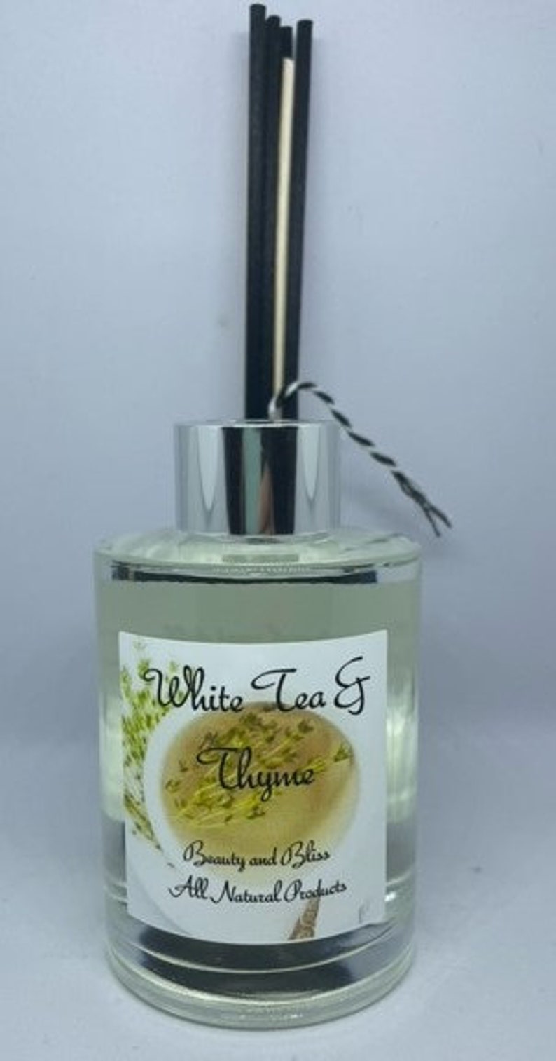 Peut inclure: Une bouteille en verre transparente avec un couvercle argent&eacute; et des roseaux noirs et blancs. La bouteille contient une huile de diffuseur avec une &eacute;tiquette qui indique "White Tea & Thyme" et "Beauty and Bliss All Natural Products".