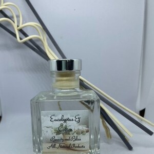 Peut inclure: Une bouteille en verre transparente avec un bouchon argent&eacute; et un bouchon en li&egrave;ge. La bouteille contient une huile de diffuseur avec une &eacute;tiquette qui indique "Eucalyptus & Cotton" et "Beauty and Bliss All Natural Products".