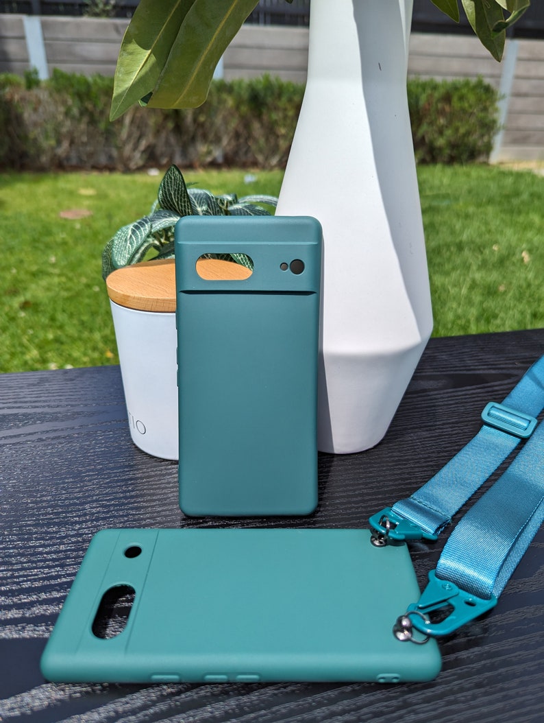 Pu&ograve; includere: Due custodie per telefono verde turchese con un laccio. Le custodie hanno un rialzo della fotocamera rialzato e una finitura liscia. Il laccio &egrave; blu e ha un clip su ciascuna estremit&agrave;.