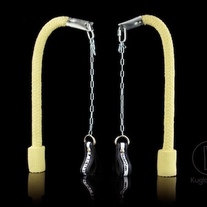 May include: Two yellow rope poi with black handles and silver chains. The poi are hanging from the chains. The background is black.
