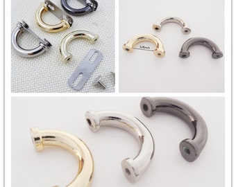 May include: A collection of U-shaped metal hardware components in gold, silver, and gunmetal finishes. The pieces feature screw-in ends and include flat mounting plates. One component is clearly labeled with a 5/8 inch measurement.