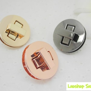 May include: Three metal round turn lock clasps in gold, rose gold, and gunmetal colours. Each clasp has a rectangular bar that secures the lock. The clasps are for bags, purses, or other craft projects.