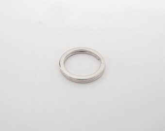 May include: A silver-colored split key ring, circular in shape, with a double-layered design. The key ring is shown against a plain white background. The product is likely used for organizing keys or as a decorative accessory.