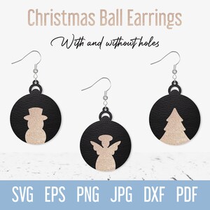 May include: Three pairs of Christmas ball earrings with different designs: a snowman, an angel, and a Christmas tree. The earrings are black with a gold glitter finish.