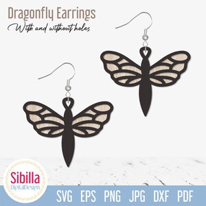 May include: A pair of dragonfly earrings with intricate cutouts. The earrings are black with a wood grain pattern and have silver hooks.