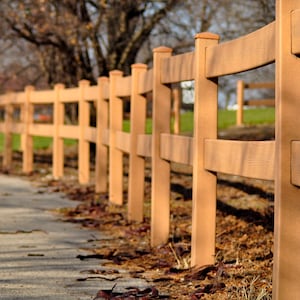 A Wooden Fence along a path by the lake on a bright autumn day.