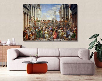 May include: A large rectangular wall art print depicting a classical Renaissance banquet scene with numerous figures in colorful robes, ornate architectural columns, and a blue sky, displayed above a light gray sectional sofa in a room.