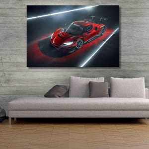 May include: A rectangular wall art print featuring a high-performance red sports car captured from a high angle. The vehicle is illuminated by bright white linear lights against a dark background, highlighting its aerodynamic body and rear wing.