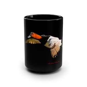 May include: Black ceramic mug with a white and orange duck in flight against a black background. The mug has the text "Austin Collection" in red at the bottom.