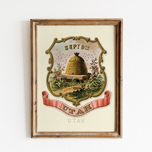 May include: A framed print of the state seal of Utah. The seal features a beehive with the date "SEPT. 9TH" above it and the word "UTAH" on a ribbon below. The seal is surrounded by a gold frame and the word "UTAH" is printed below the seal.