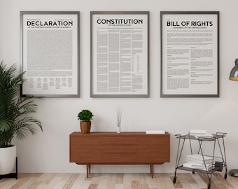 May include: Three framed prints of the Declaration of Independence, the Constitution of the United States, and the Bill of Rights. The prints are hanging on a white wall above a brown wooden dresser and a black metal rolling cart.