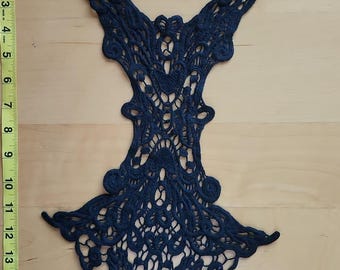 May include: A navy blue lace applique, approximately 12 inches long, with an intricate floral and geometric design. The applique features a symmetrical pattern with delicate openwork and decorative edges, suitable for embellishing garments.